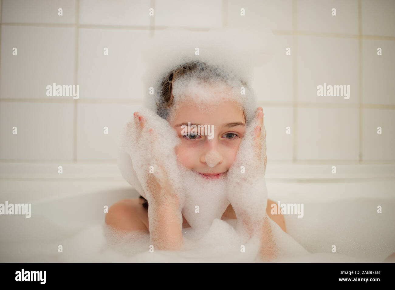 Junge Mädchen In Der Badewanne Ein Kleines Mädchen Taucht In Der Badewanne Mit Schaum Ein 