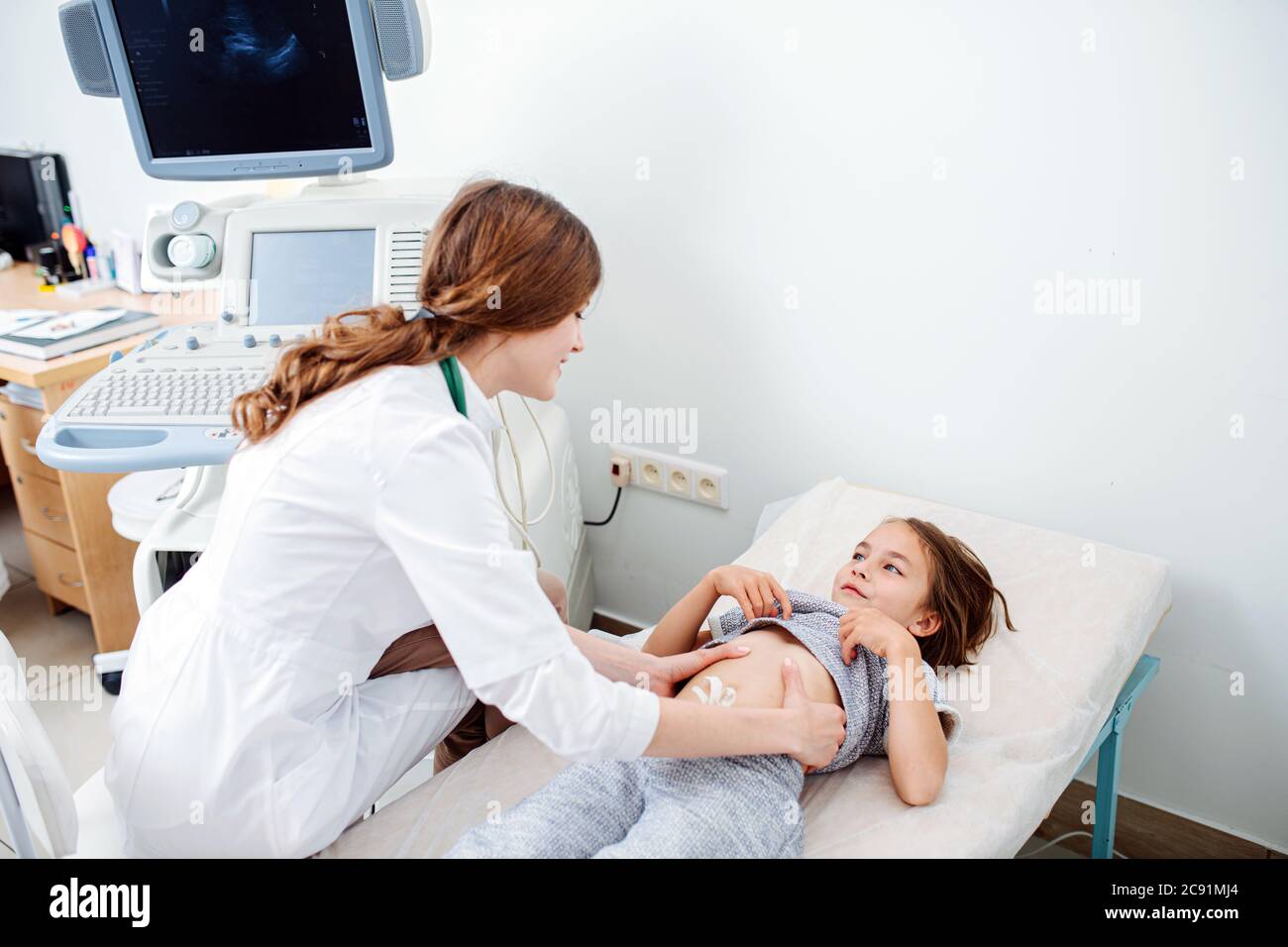 Hoher Winkel Der Freundlichen Weiblichen Arzt Untersuchung Kleinen Mädchen Bauch Stockfotografie 