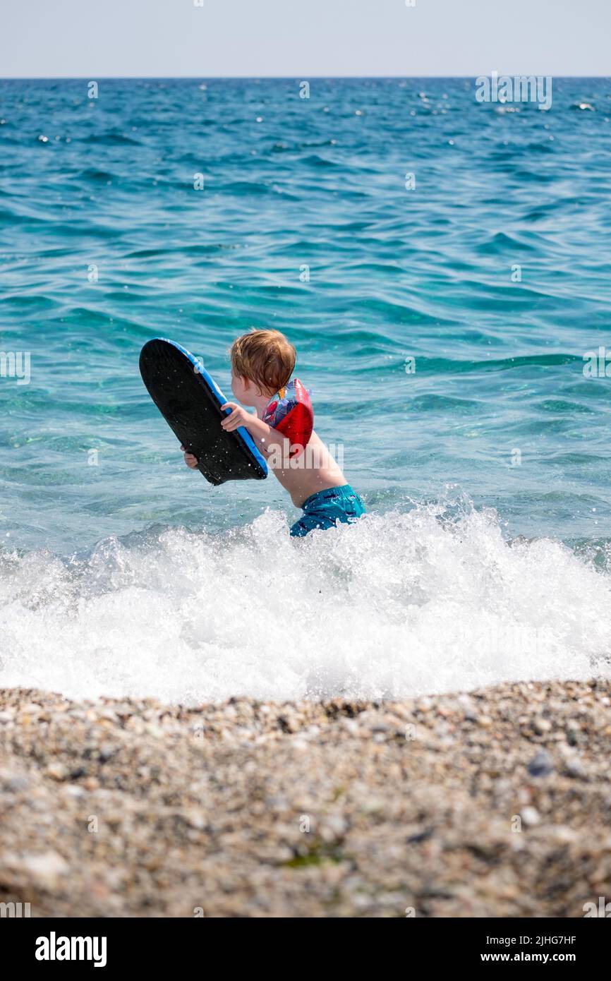 Entzückender Kleiner Junge Der Mit Seinen Aufblasbaren Armbändern Und Einem Schwimmbrett Im 