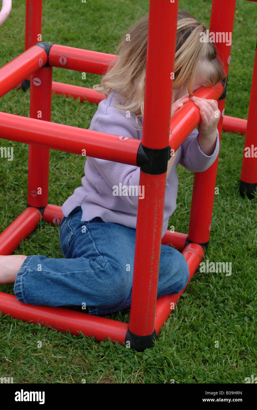 Kleines Mädchen Sitzt In Einem Klettergerüst Stockfotografie Alamy 