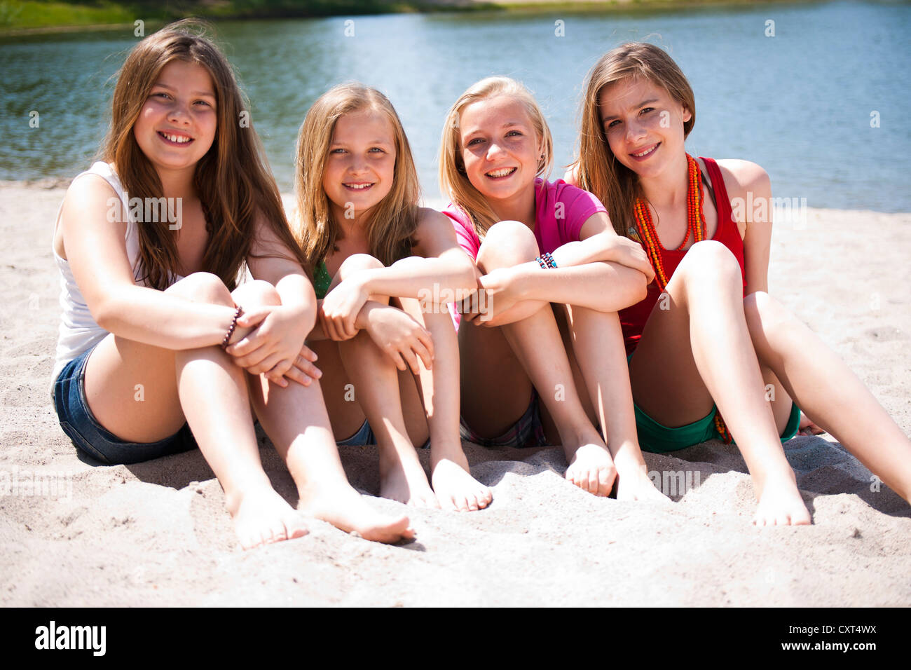 Gruppe Von Mädchen Am Strand Eines Sees Sitzen Stockfotografie Alamy 