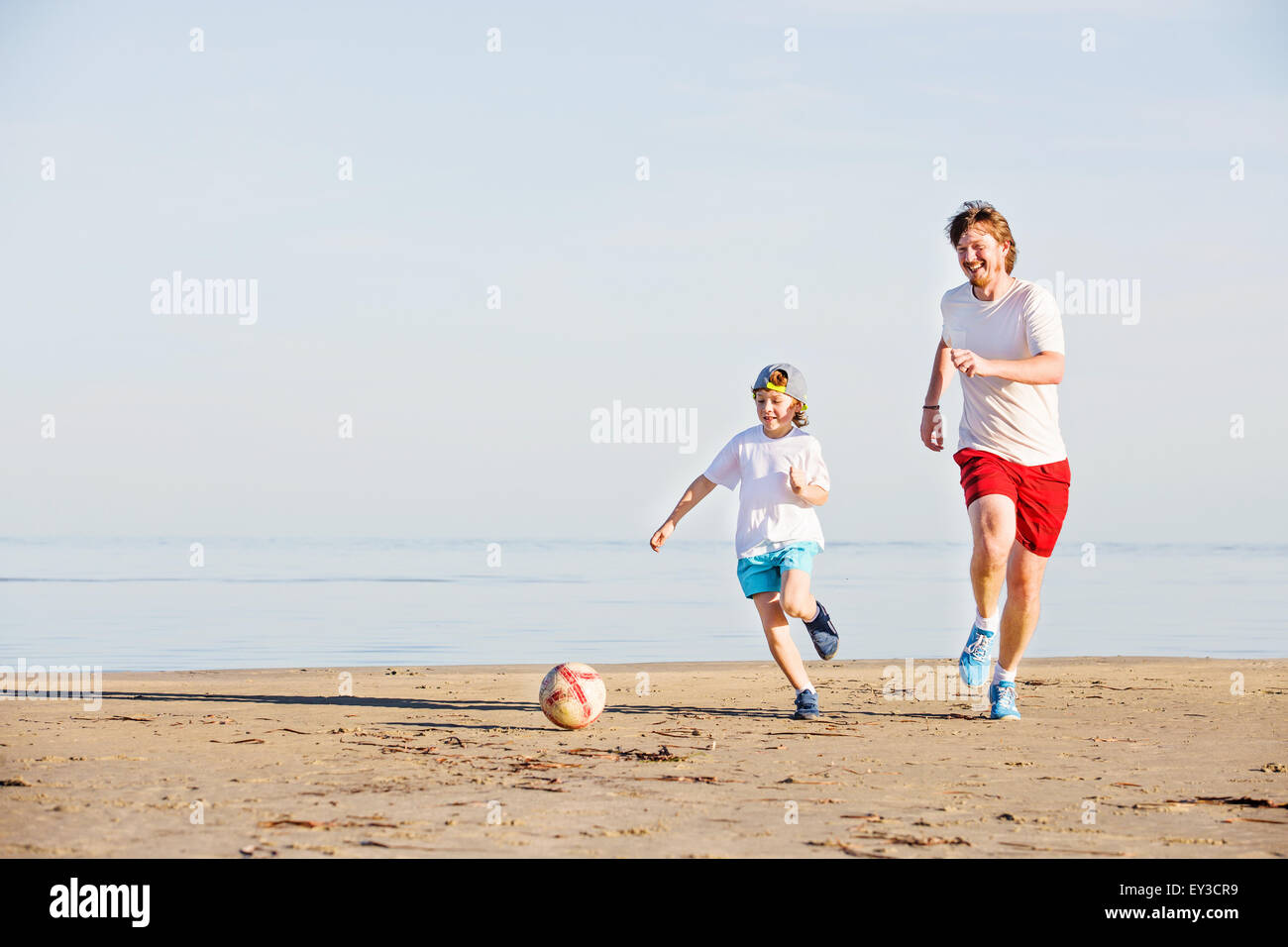 Glücklicher Vater Und Sohn Spielen Fußball Oder Fußball Am Strand Stockfotografie Alamy