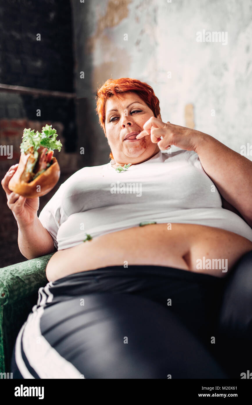 Fette Frau Sitzt In Einem Sessel Und Isst Sandwich Übergewicht Fettsäuren Und Bulimic 7808