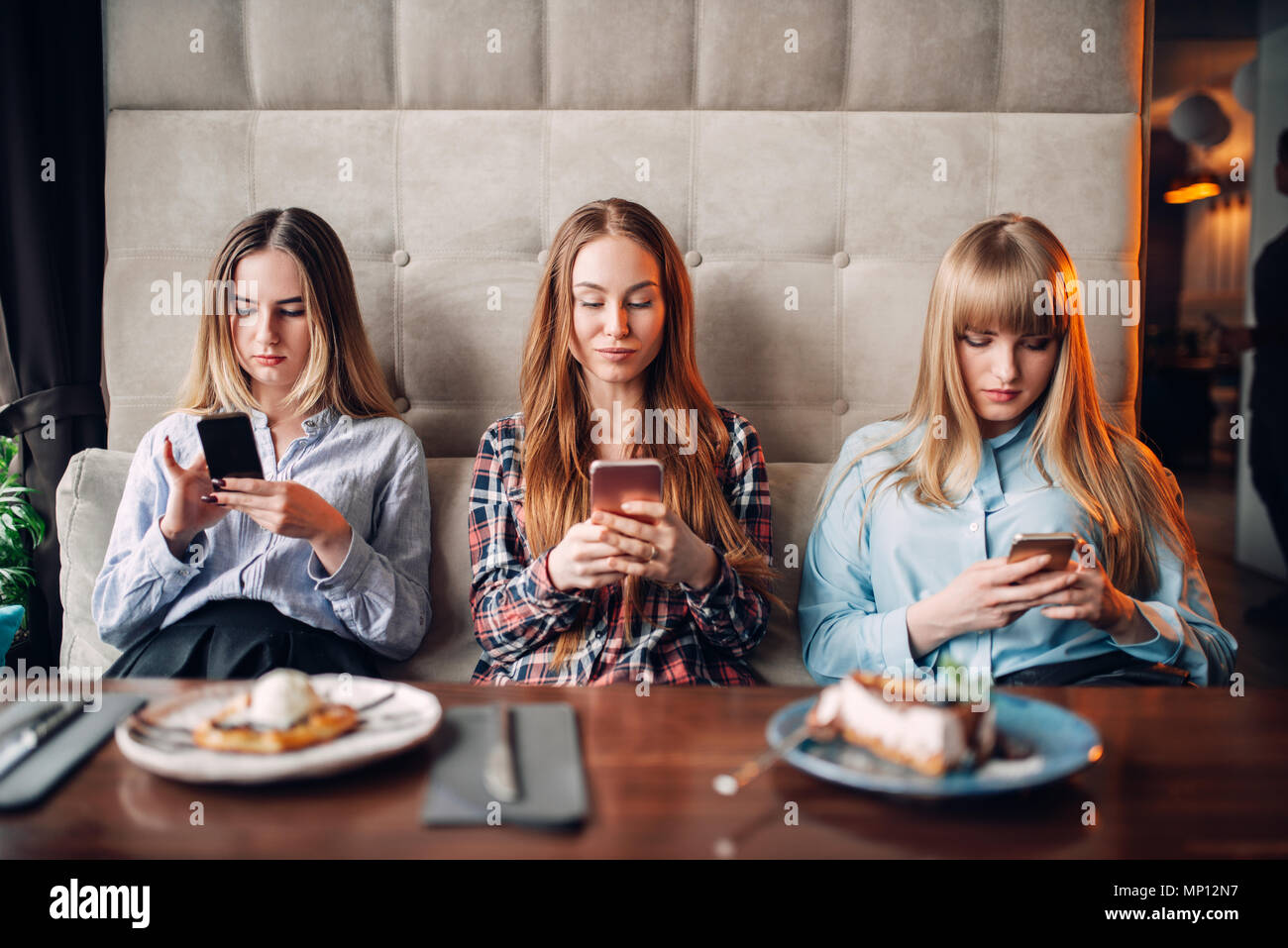 Drei Mädchen Sitzen Auf Der Couch Und Die Verwendung Von Mobiltelefonen Im Cafe Schokolade